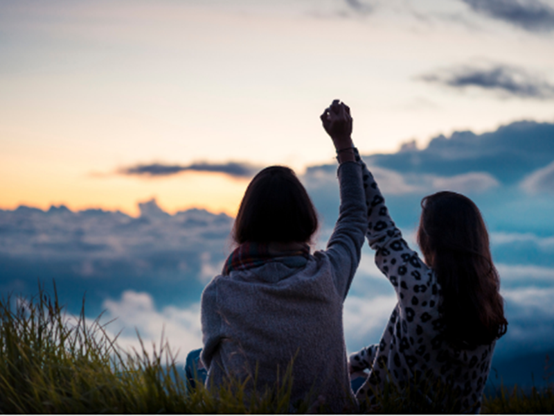 two women holding raised hands