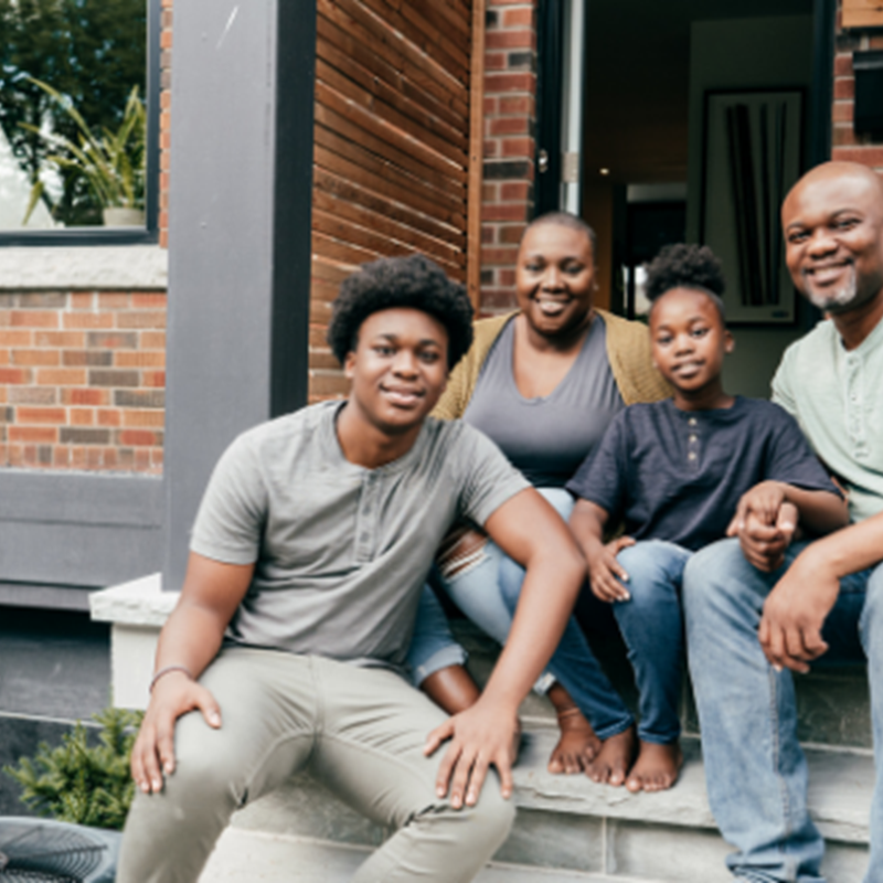family of four sitting on front porch